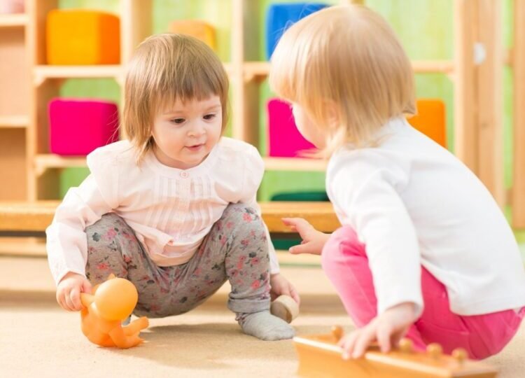 Two kids playing in kindergarten room